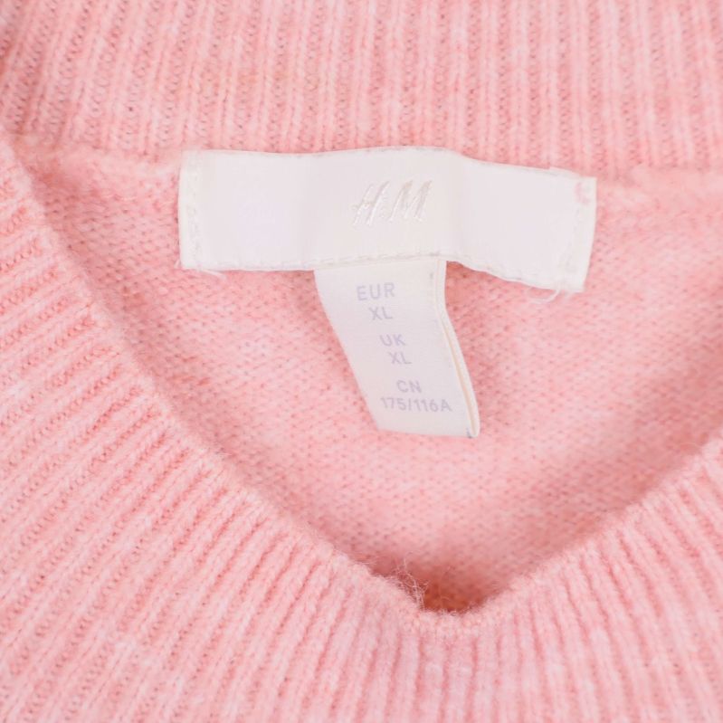 Närbild på etikett i nacken med storlek XL och H&M-logga