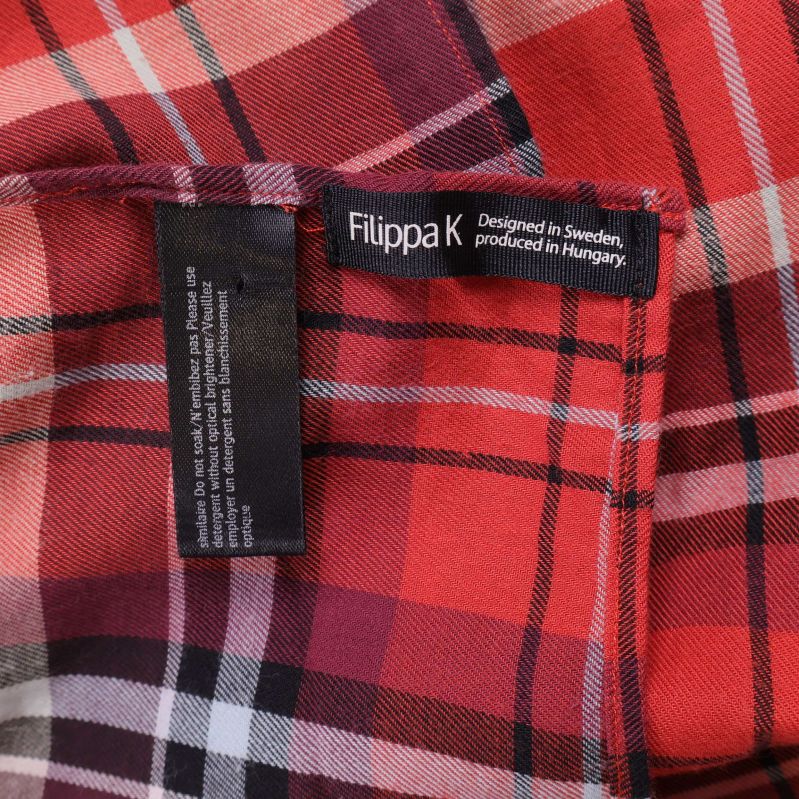 Närbild på Filippa K-logga och etikett i kjolen
