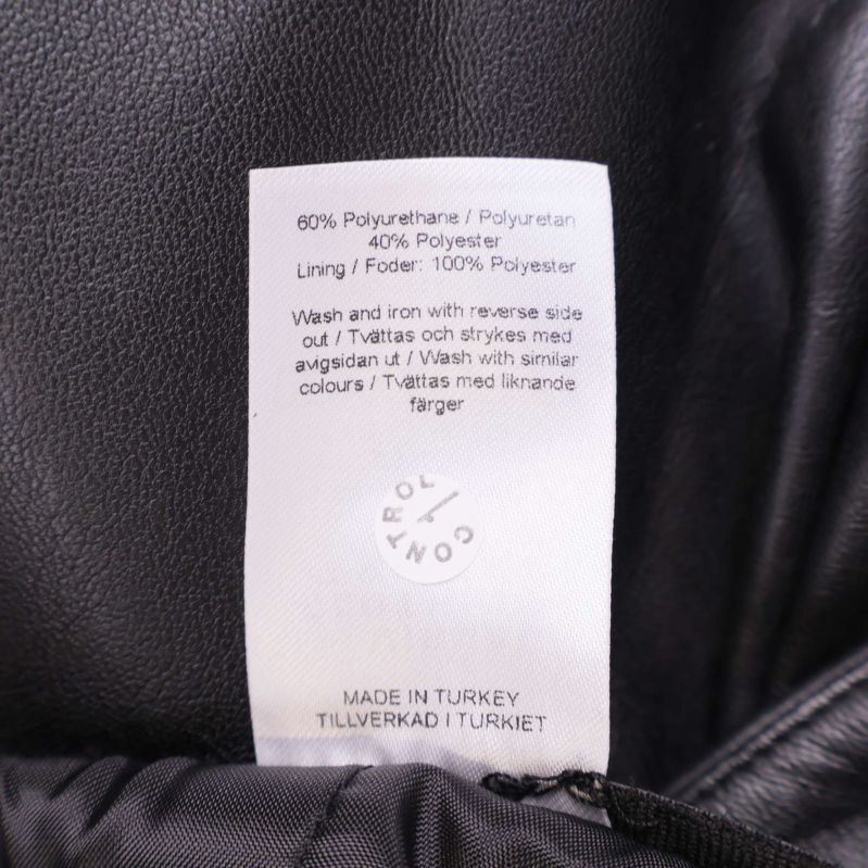 Närbild på materialetikett som visar 60% polyuretan, 40% polyester och foder 100% polyester