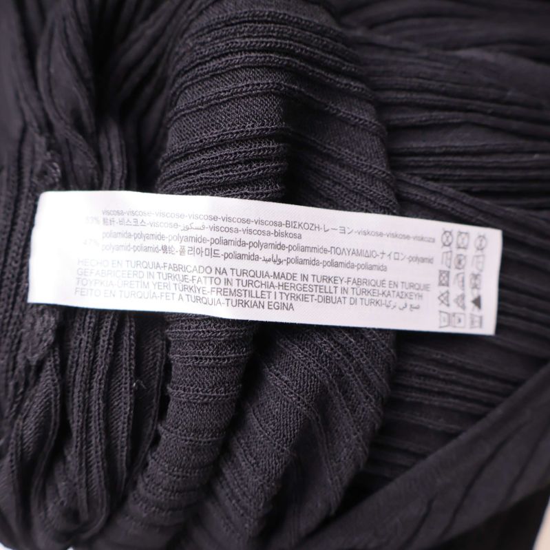 Materiallapp i svart jumpsuit visar materialinformation
