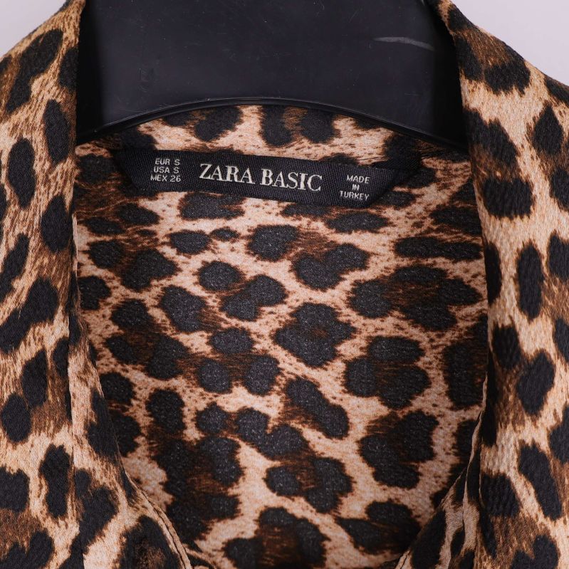 Närbild på etikett Zara Basic i leopardmönstrad krage