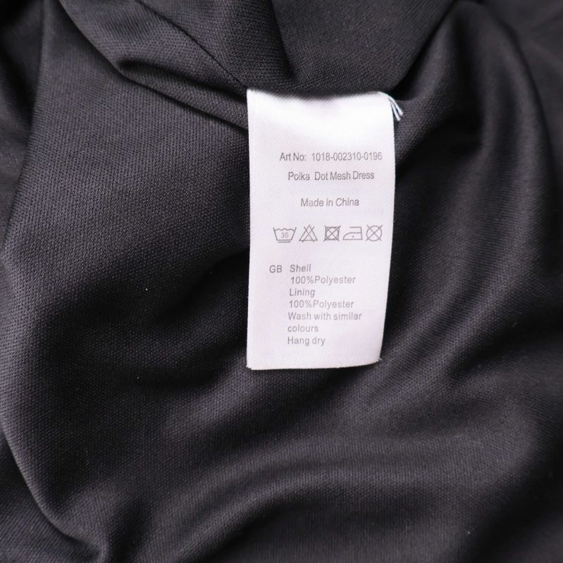 Materialetikett som visar 100% polyester för både skal och foder
