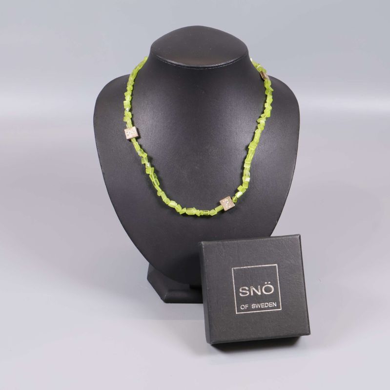 Limegrönt pärlhalsband på svart halsdisplay med SNÖ of Sweden-ask