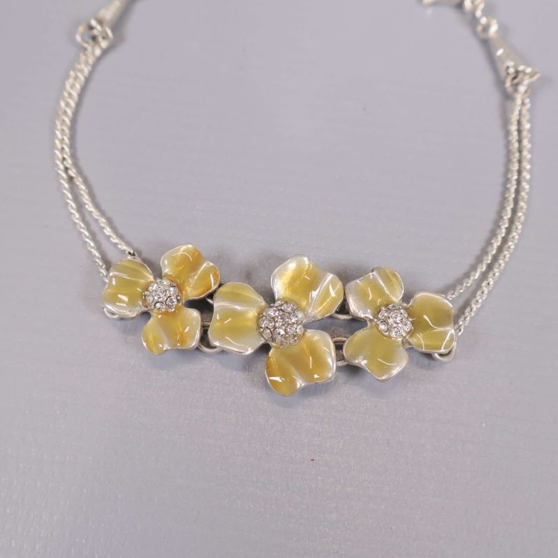 Närbild på armbandets blommor och dekorstenar