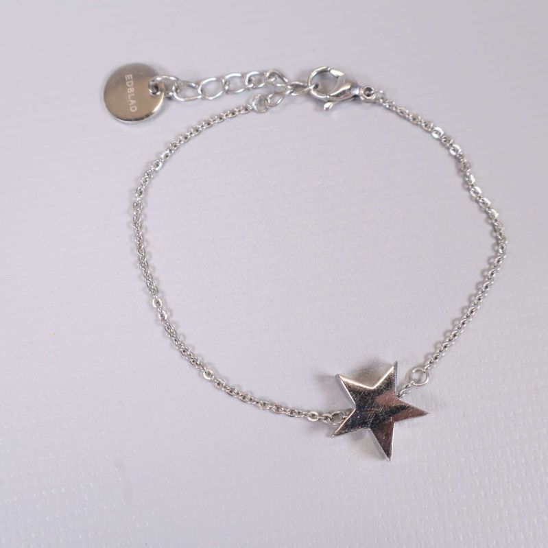 Närbild på armbandets stjärndetalj och kedja