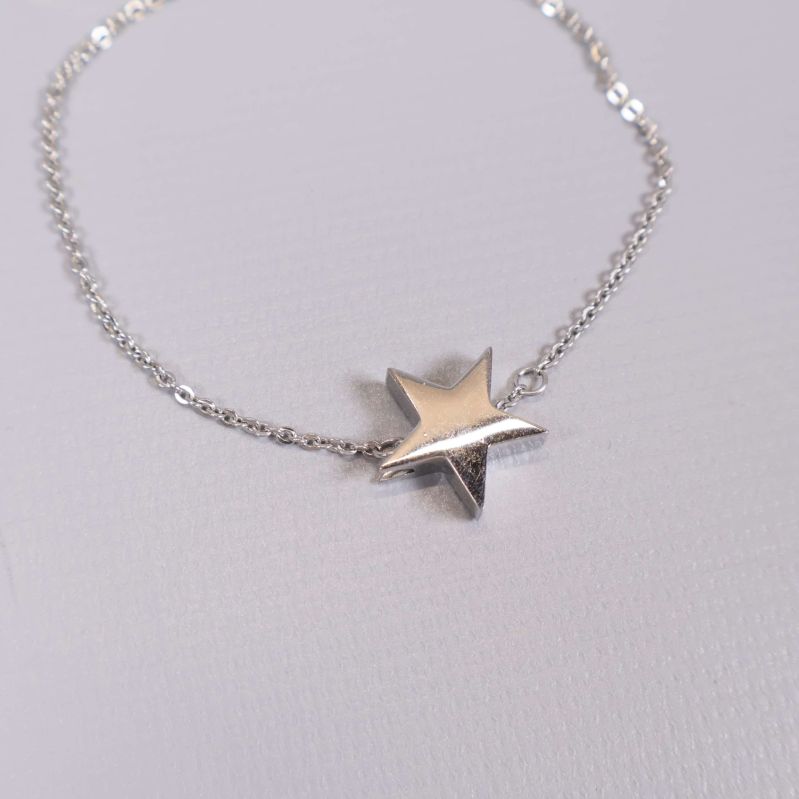 Närbild på glänsande stjärnberlock på armbandet