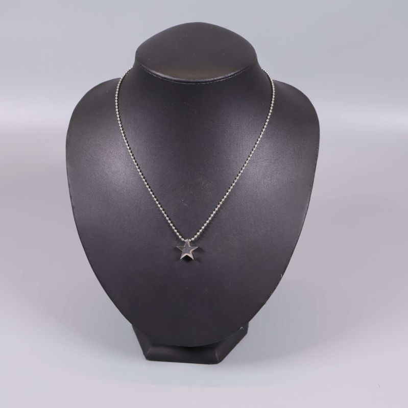 Halsband med stjärnformat hänge på svart byst