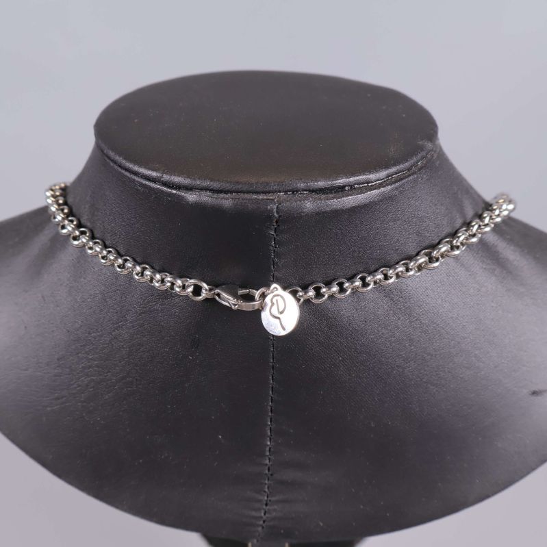 Baksida av halsband med lås och liten silverbricka