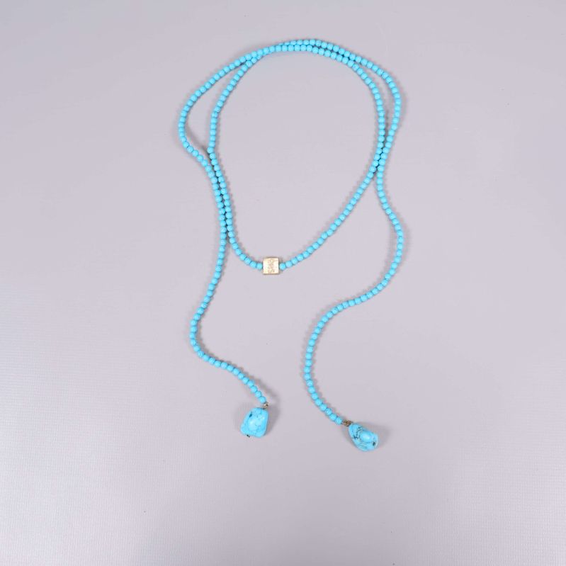Halsband med pärlor och dekor ligger utsträckt mot ljus bakgrund