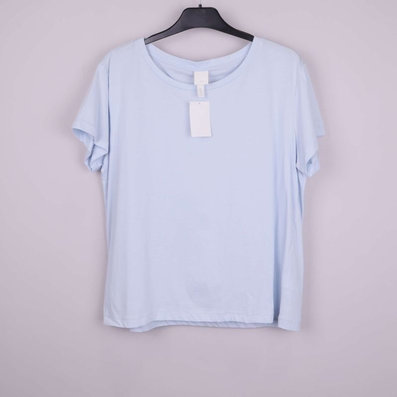 Ljusblå t-shirt upphängd framifrån på galge