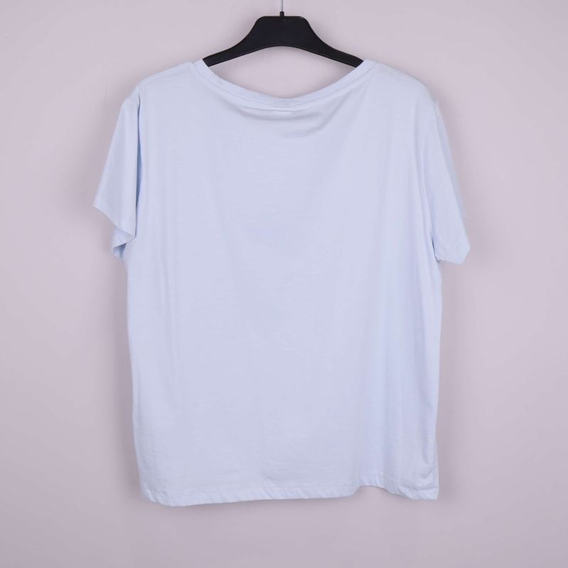 Ljusblå t-shirt bakifrån på galge