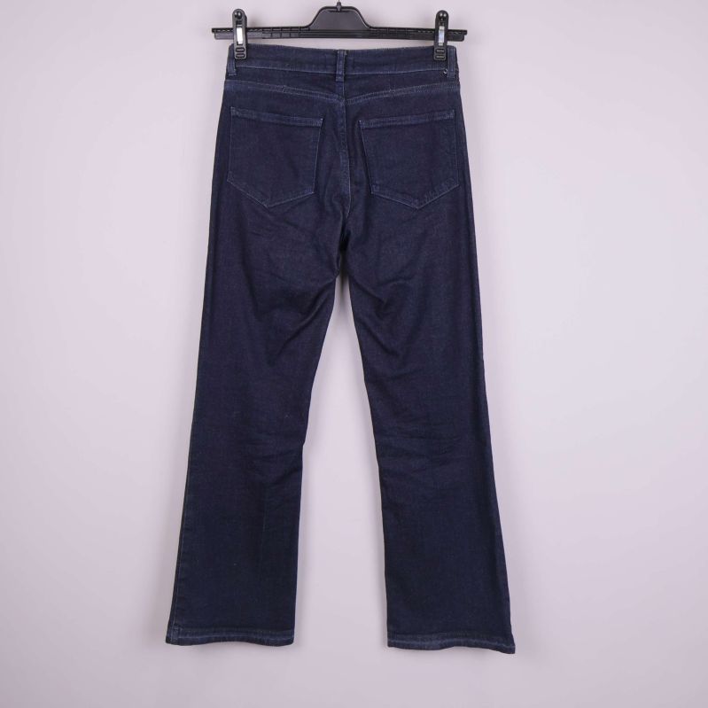 Baksida av mörkblå raka jeans på galge