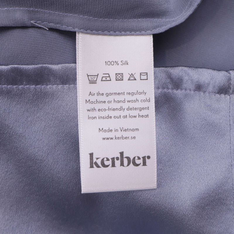 Materialetikett som visar 100% silke från Kerber