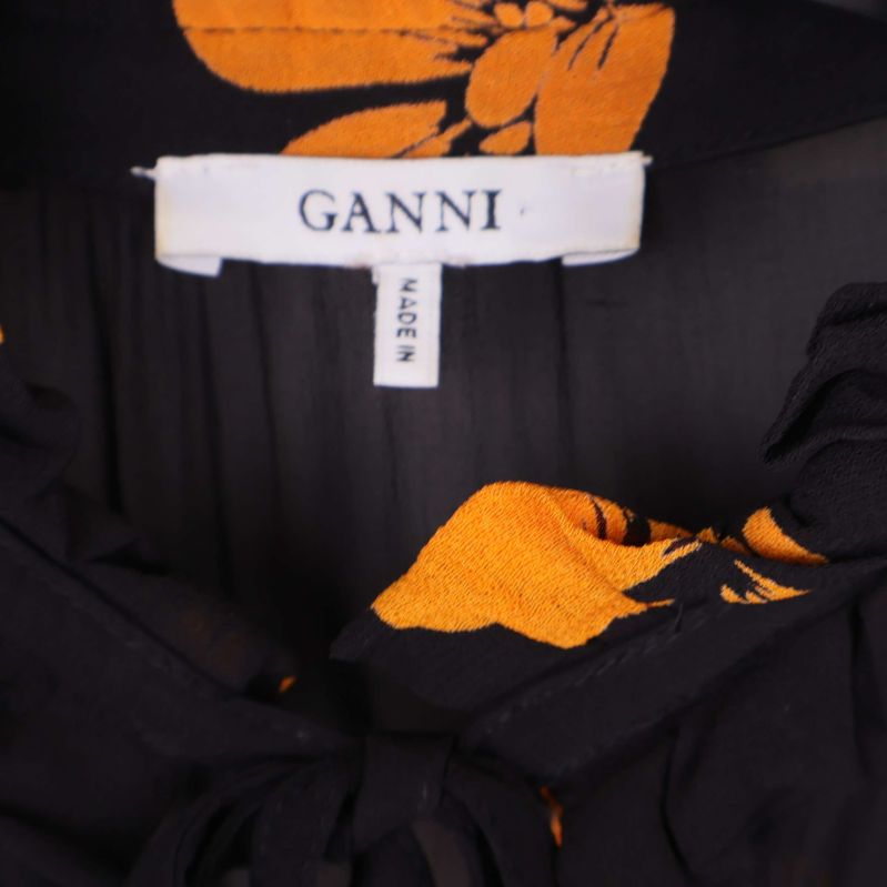 Närbild på Ganni-logotyp och etikett i klänningens krage