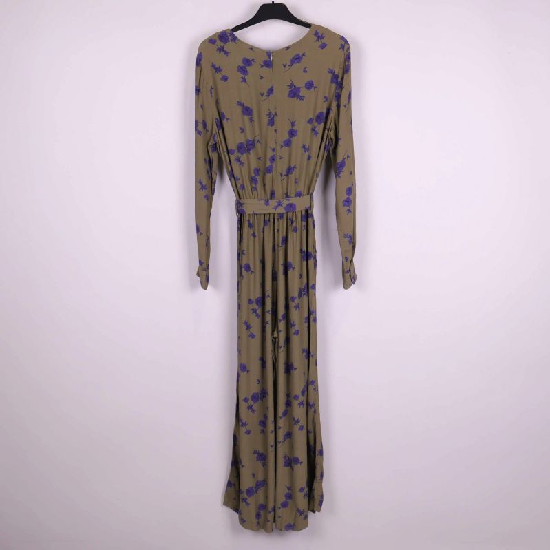 Jumpsuit i khakigrönt med lila blommönster bakifrån på galge