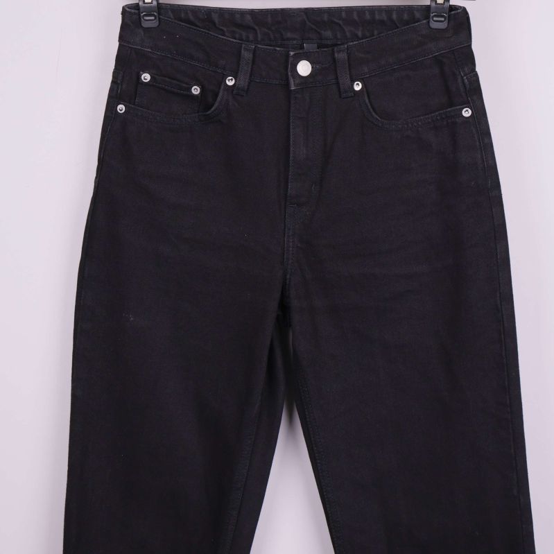 Närbild på midja och fickor framtill på svarta jeans