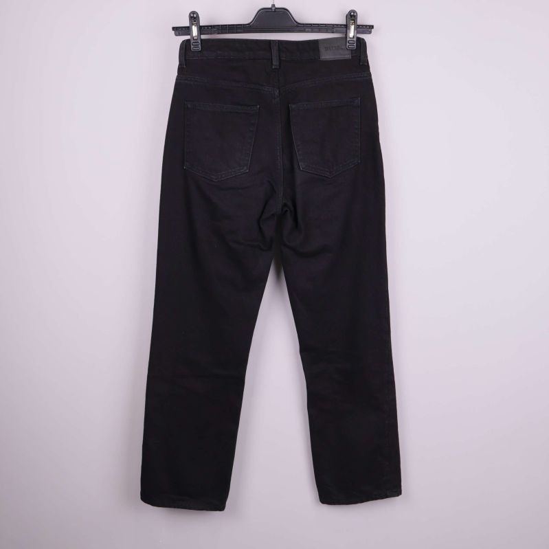 Baksidan av svarta jeans med fickor och etikett