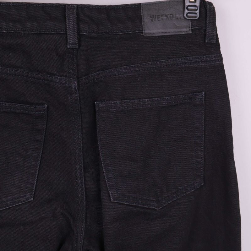 Närbild på bakfickor och logga på svarta jeans