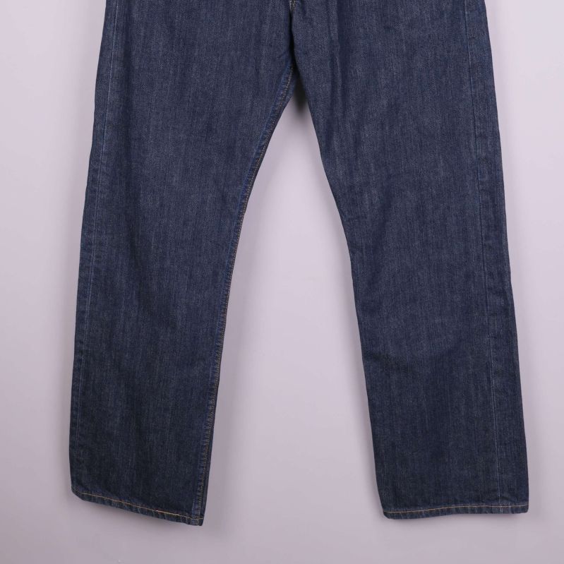 Ben och avslut på raka mörkblå jeans mot ljus bakgrund