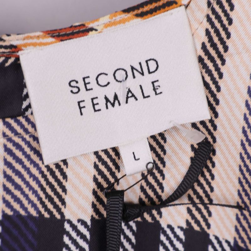 Närbild på etikett med Second Female och storlek L