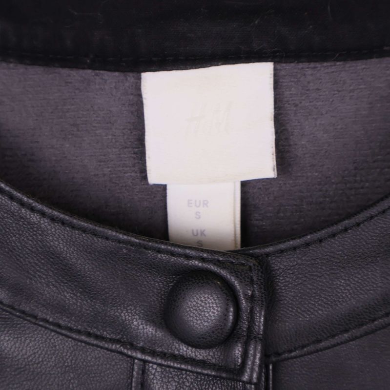 Närbild på H&M-lapp med storlek small i kragen