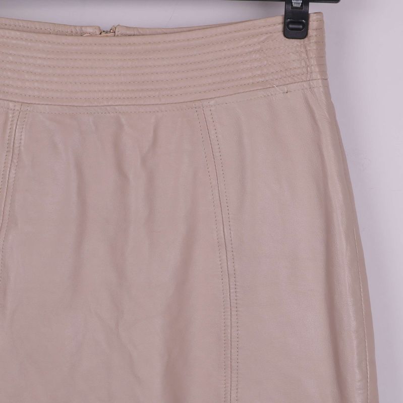 Närbild på midja och struktur i beige läder