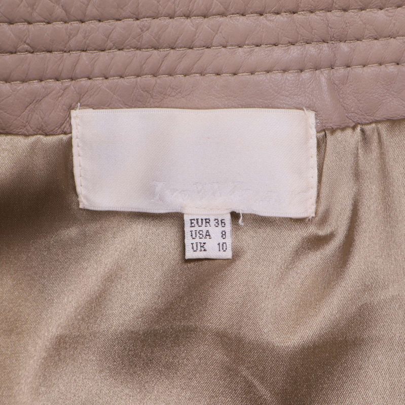 Storleksetikett med EUR 36 i beige kjol