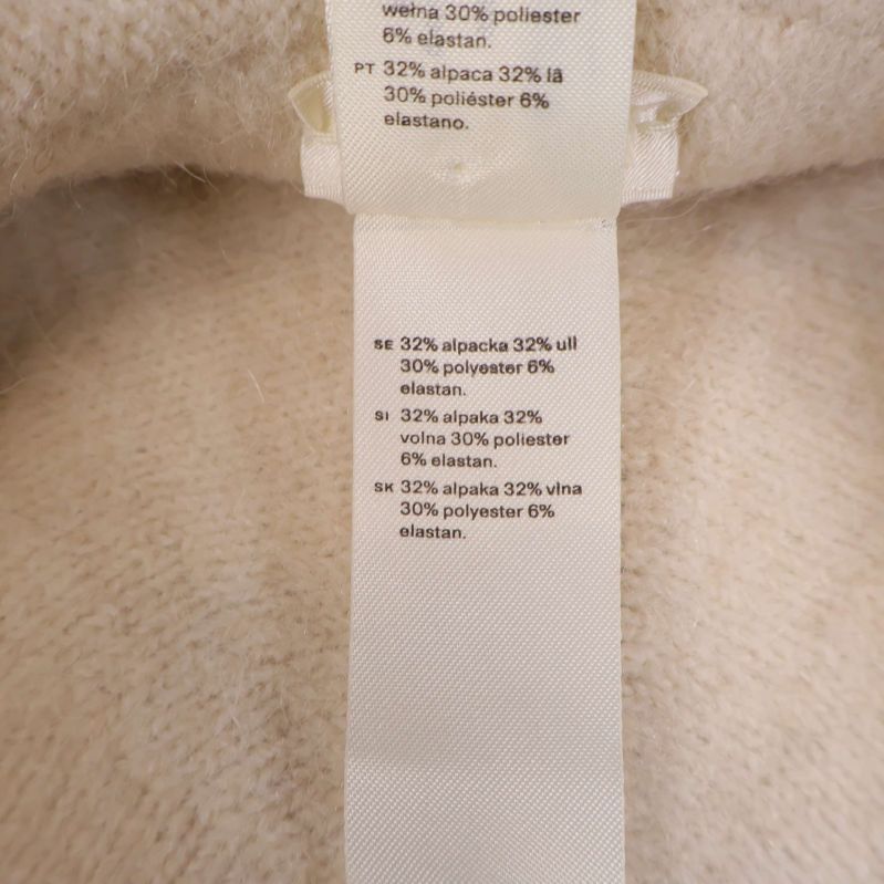 Materialetikett visar alpacka, ull, polyester, elastan