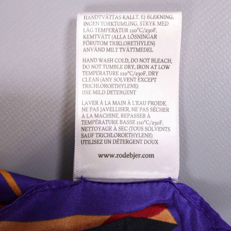 Ettikett med skötselråd på svenska, engelska och franska