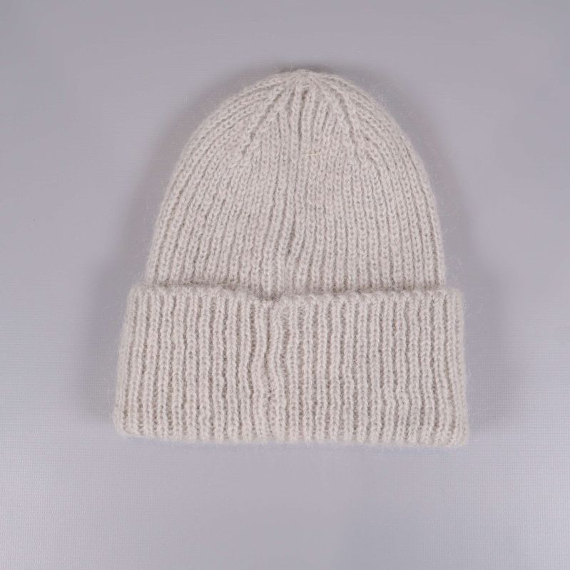 Beige stickad mössa sedd bakifrån med bred kant
