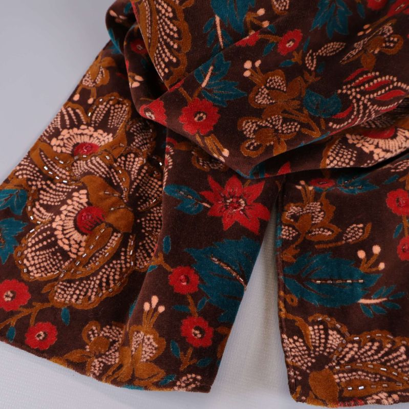 Närbild på blommönstrad textil i brunt och rött