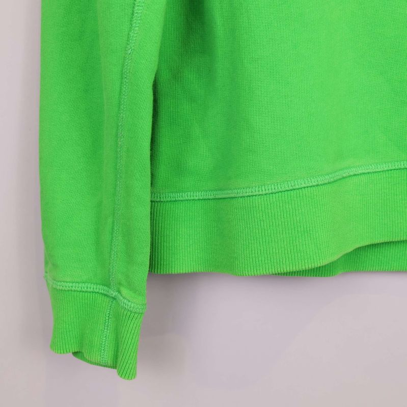 Nederkant och ärmslut på grön sweatshirt