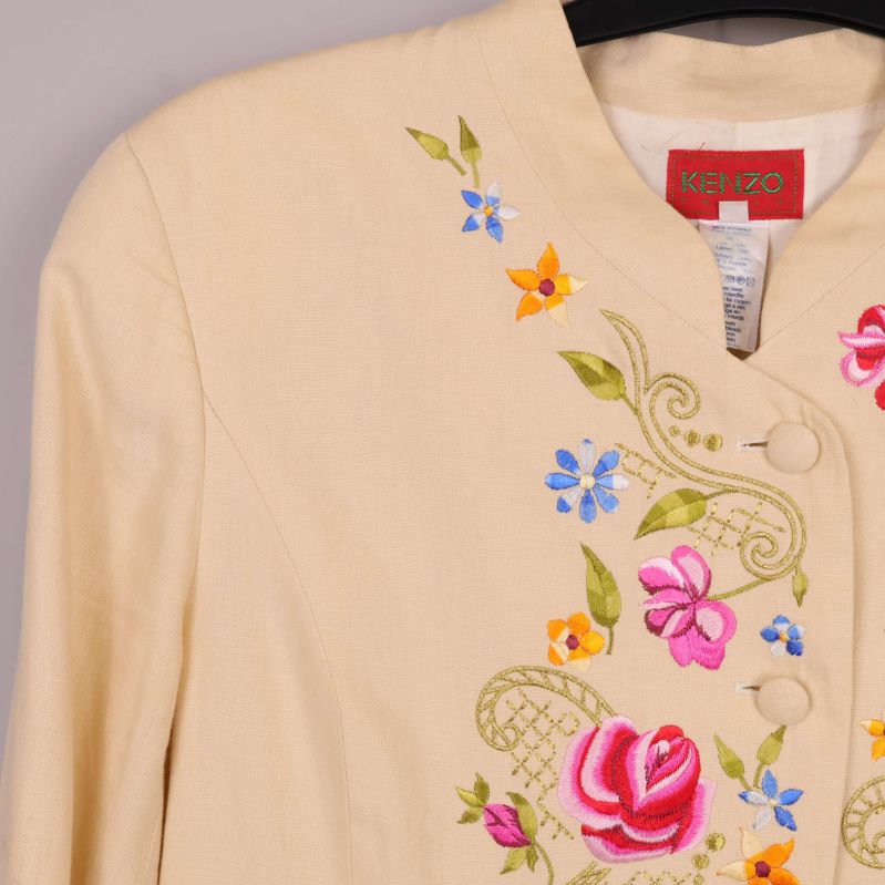 Detaljbild på broderade blommor vid axelpartiet