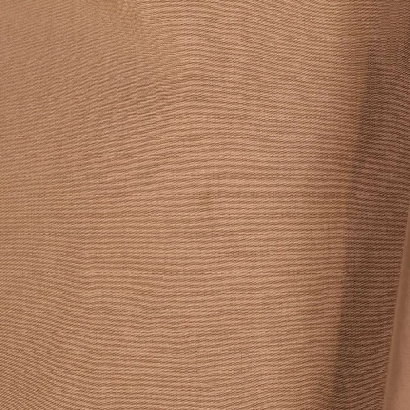 Liten rund fläck synlig på beige bomullsblus