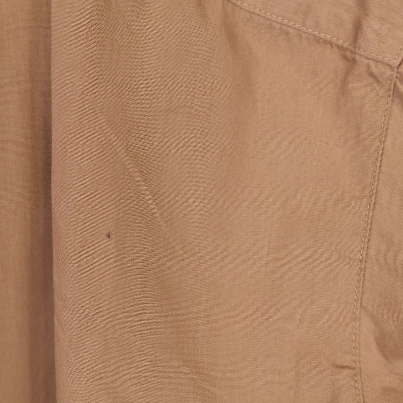 Mindre märken och prick på baksidan av beige blus