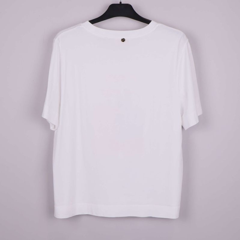 Baksida av vit t-shirt på galge
