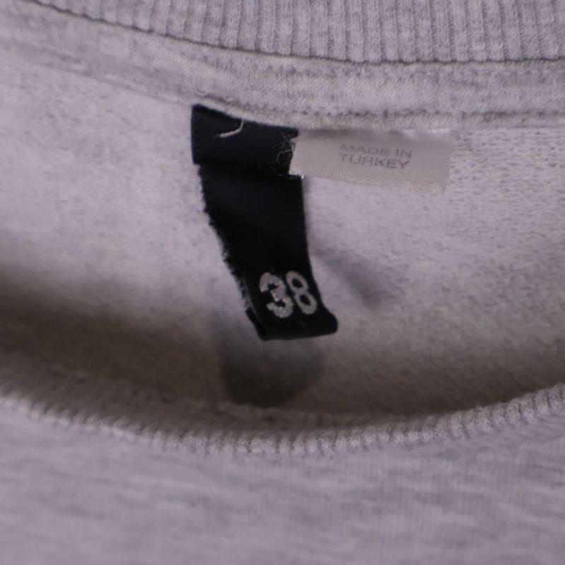 Storleksetikett 38 i halsen på sweatshirten