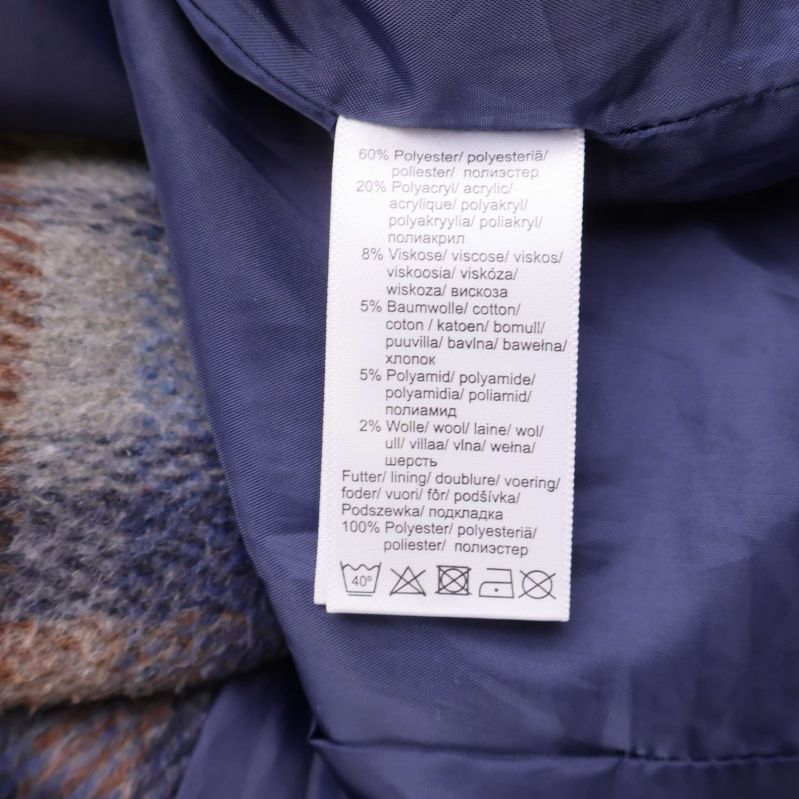 Material- och tvättrådsetikett i kappan visar materialblandning