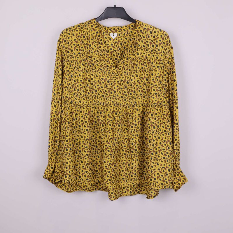 Blommig blus i gult med svarta detaljer, framifrån
