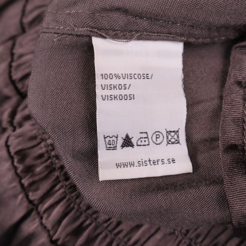 Materiallapp som visar 100% viskos på blus