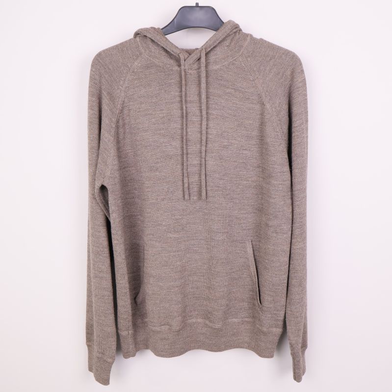Gråbeige hoodie med huva och ficka hängande på galge