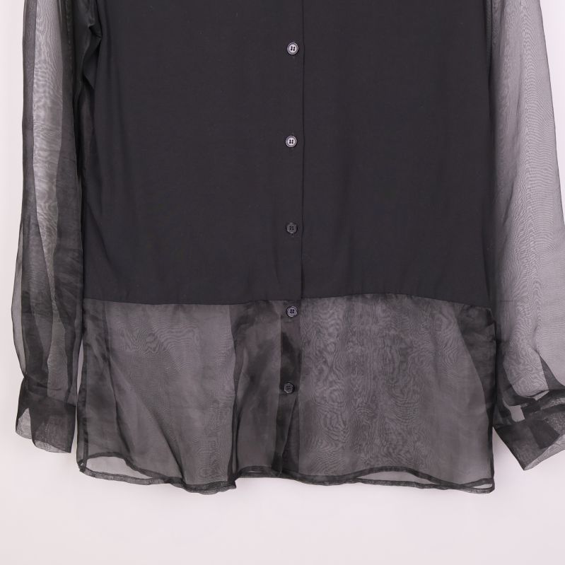 Nederdel av svart blus med transparent tyg