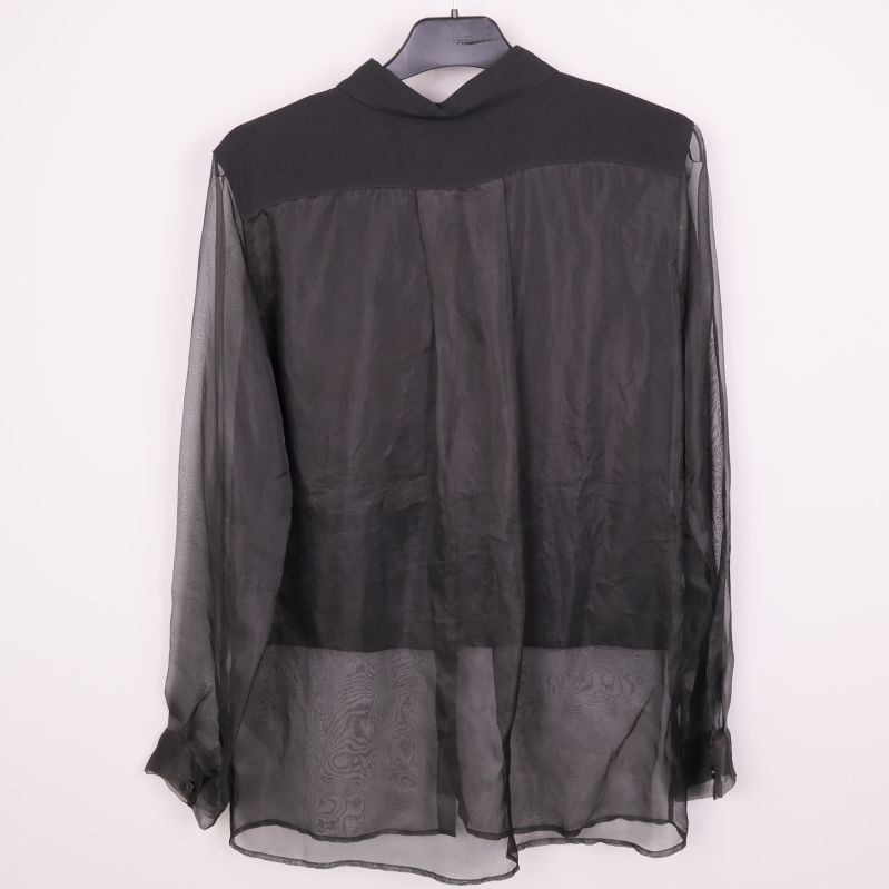 Svart blus med transparenta partier visad bakifrån