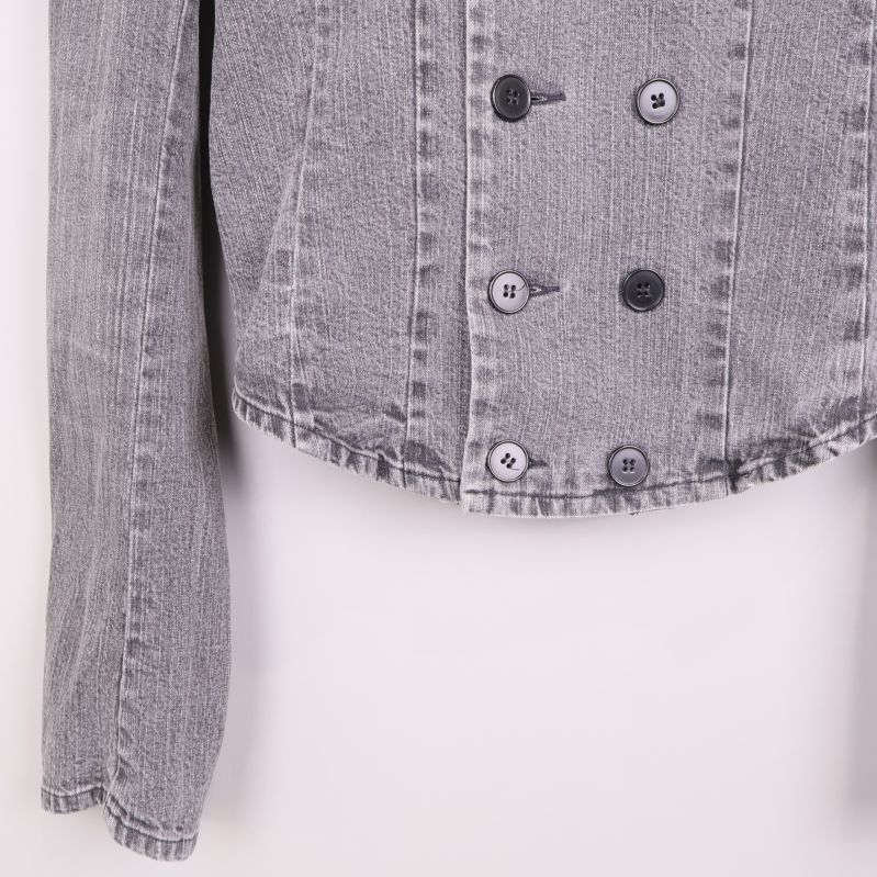 Närbild på knappdetaljer och fåll på denimjacka