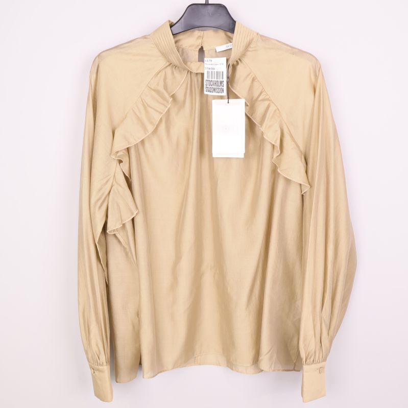 Beige långärmad blus med volangdetaljer framtill