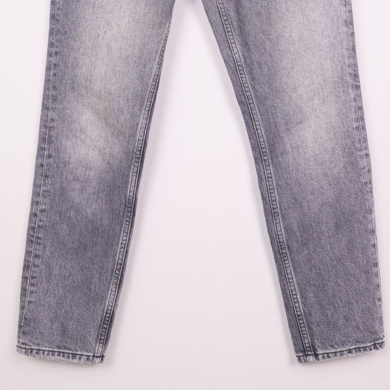 Benens nedre del på raka grå jeans