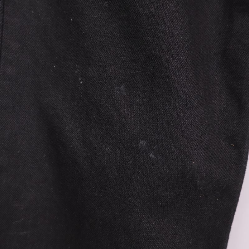 Närbild på svarta jeans med synliga ljusa fläckar