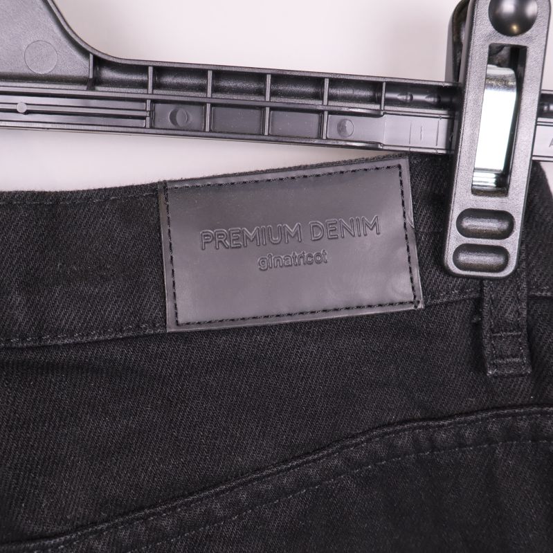 Svart läderlapp med texten Premium Denim på jeansens baksida
