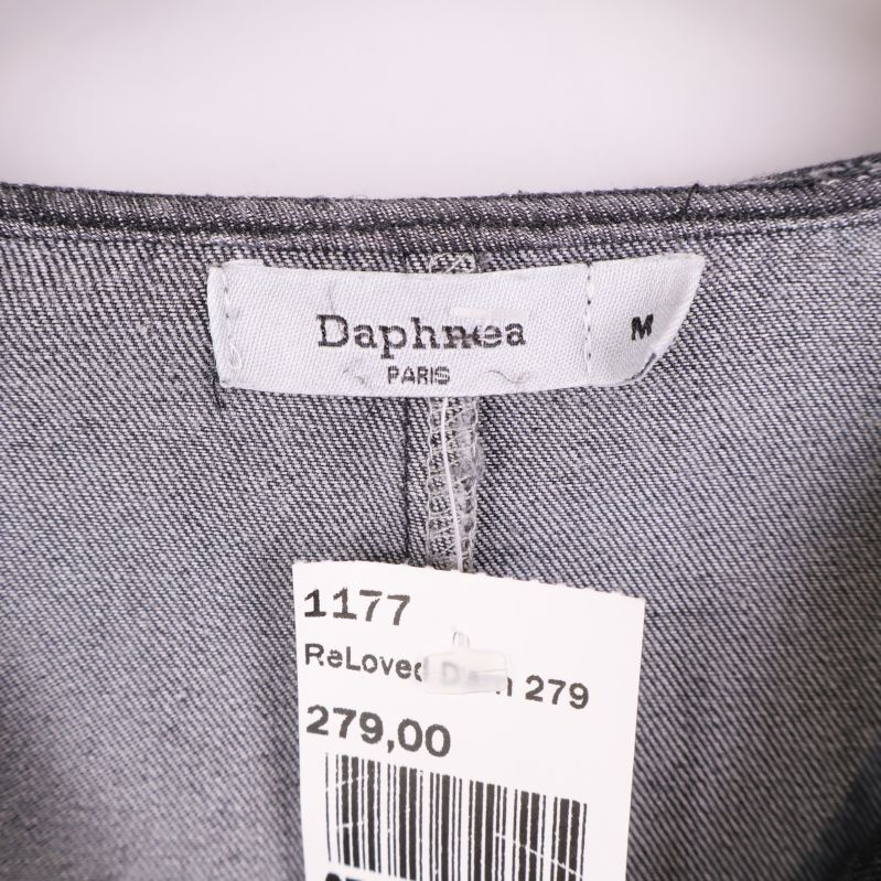 Tygmärke med texten Daphnea Paris och storlek M