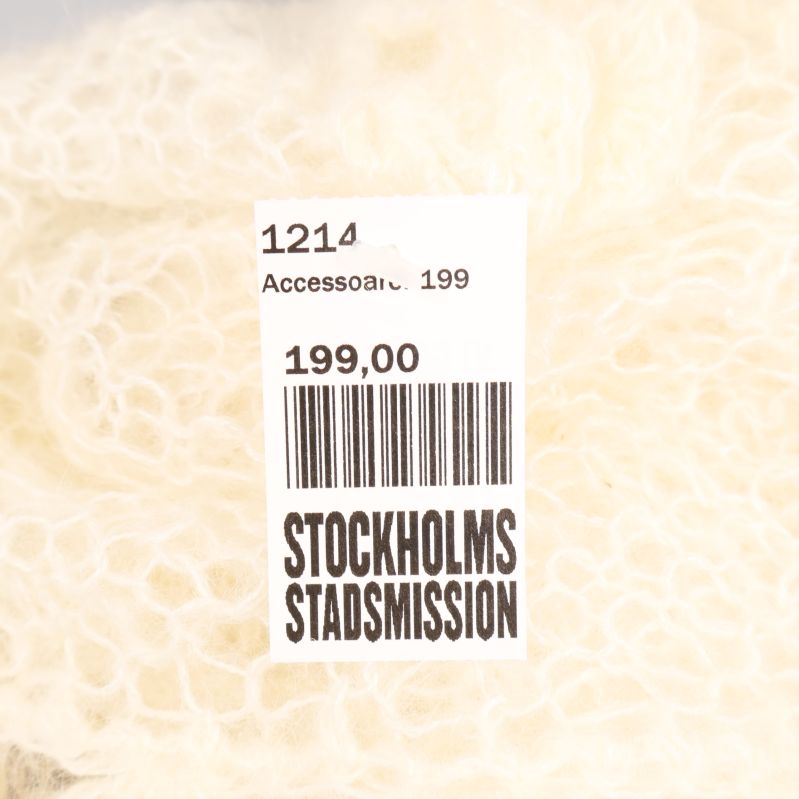 Prislapp på vit stickad halsduk från Stockholms Stadsmission